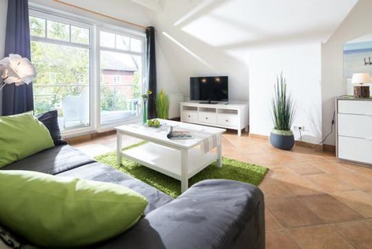 Wohnzimmer mit TV und großem Sofa und Sesseln